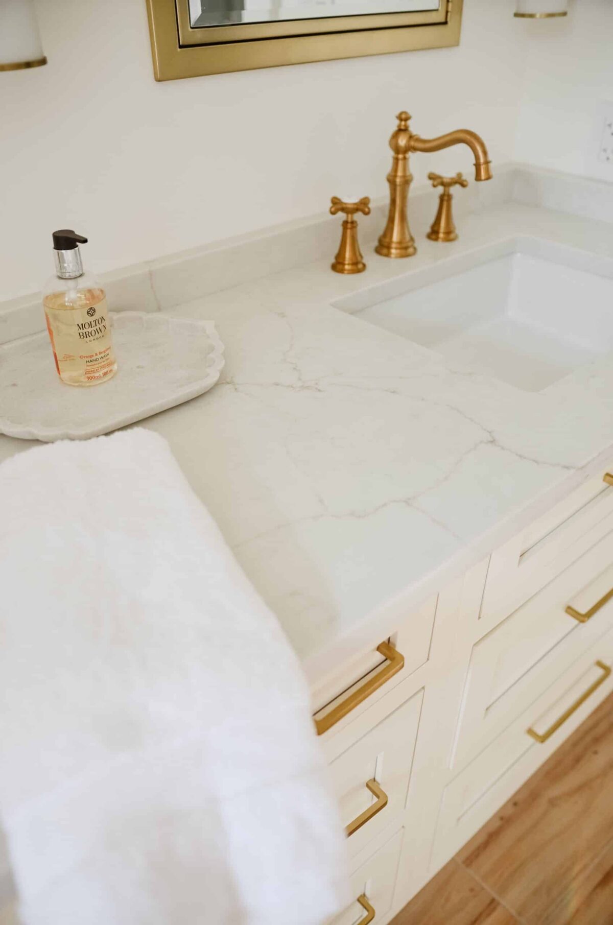 marble counters with gold hardware in bathroom renovation