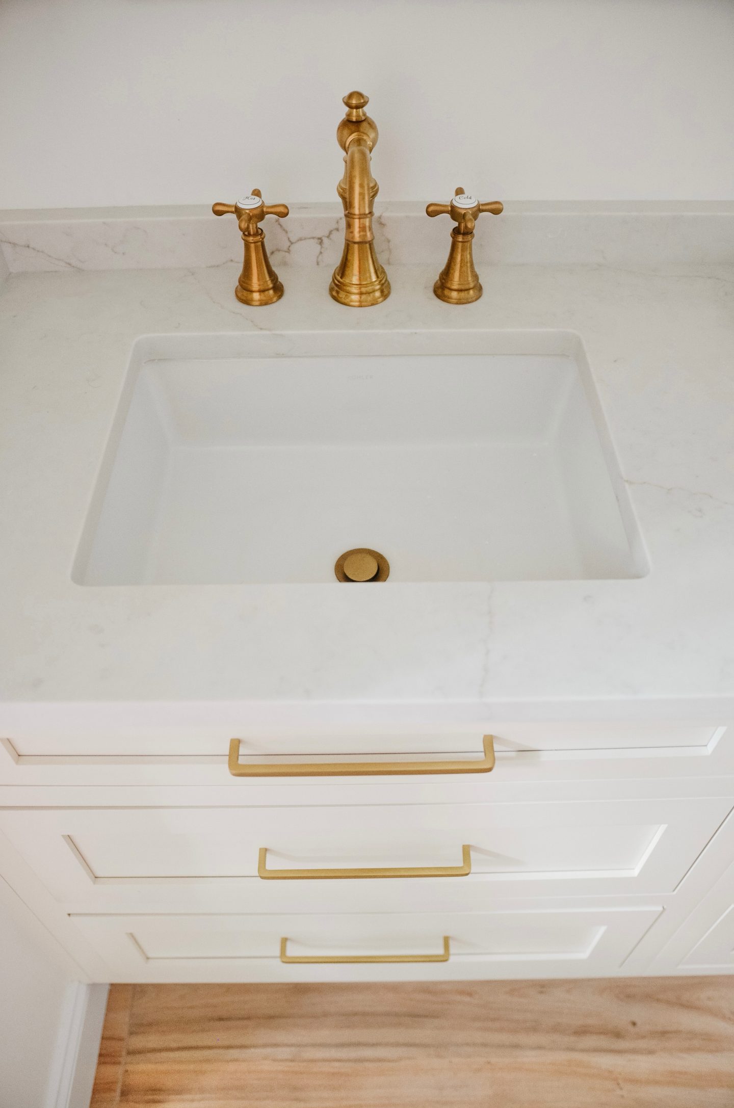 marble counters with gold hardware in bathroom renovation