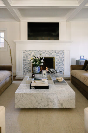 modern living room with oversized marble coffee table and blue tile mantel